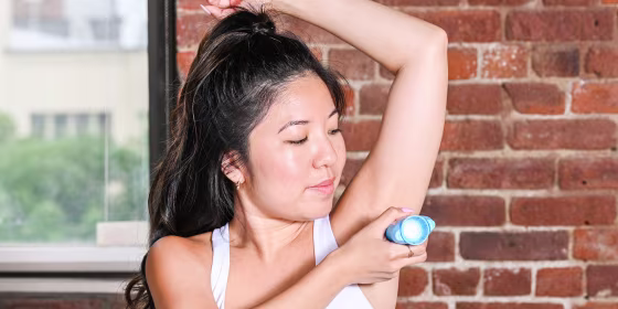Woman putting on deodorant