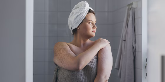 Beautiful Plus Size Woman Applying Body Lotion after Taking a Shower