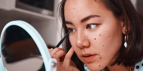 Woman putting on eyeliner