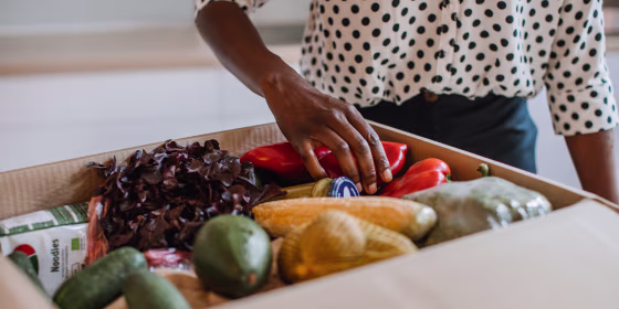 African Woman Opening Parcel With Meal Kit