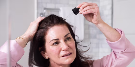 Woman putting serum in her hair