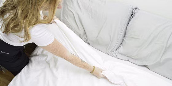 Overhead of someone making the bed