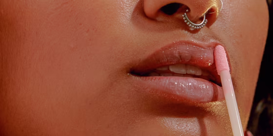 Woman putting on lip oil