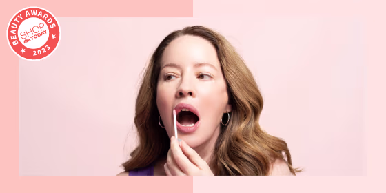 Woman putting on lip gloss
