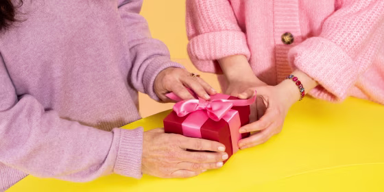 Two hands holding onto a gift basket