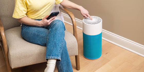 Woman pressing the button on a Blue Air Purifier