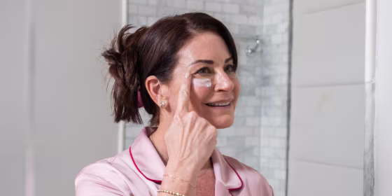 Woman putting lotion on her face