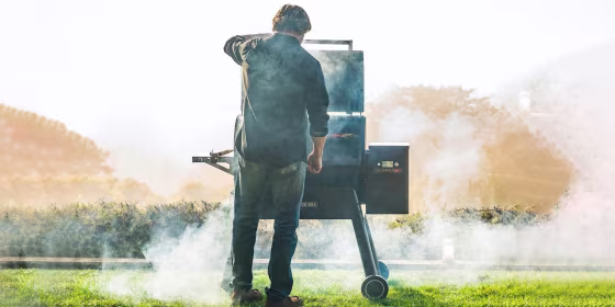 Man standing outside in front of a smoker