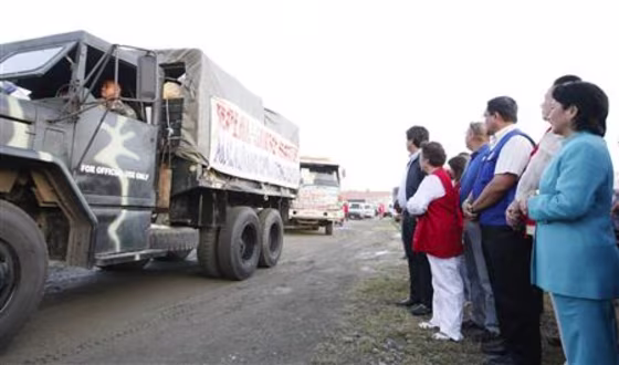 Philippines' President Gloria Macapagal Arroyo looks at a military truck full of relief goods to be sent to areas in the central Luzon province, north of Manila