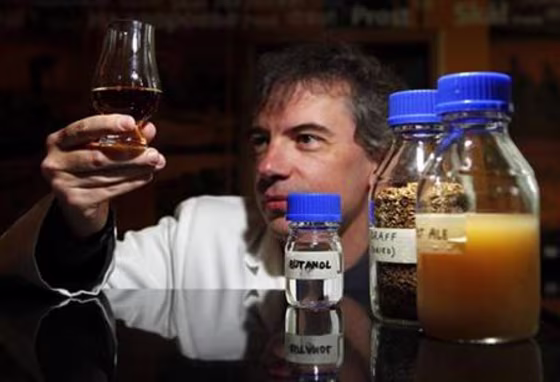 Professor Martin Tangey holds a glass of whisky during a media viewing in Edinburgh