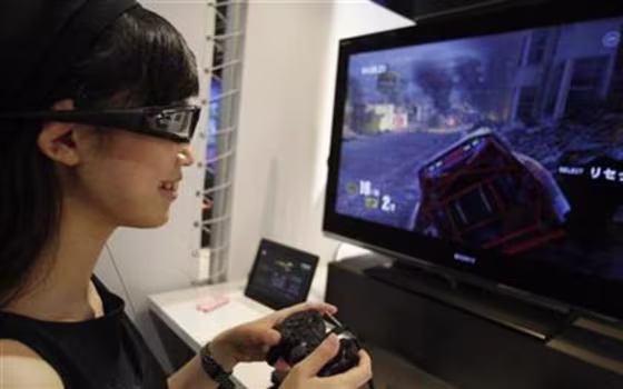 An attendant demonstrates Sony's 3D game on the PlayStation 3 game console at Tokyo Game Show in Chiba, east of Tokyo