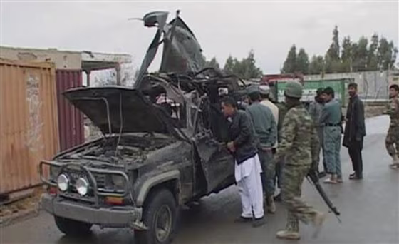 A video grab shows security personnel examining the damaged vehicle belonging to the deputy governor of Afghanistan's southern Kandahar province, after an attack in Kandahar city