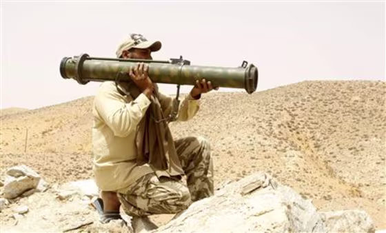 A rebel fighter carrying a weapon is seen at his position outside the Bir-Ayyad gate near the city of Zintan in the western mountains