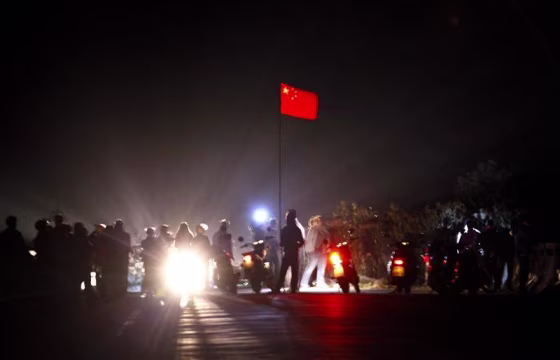 The Chinese national flag flies from a make-shift mast as residents of the village of Wukan in Lufeng county, Guangdong province remove a barricade