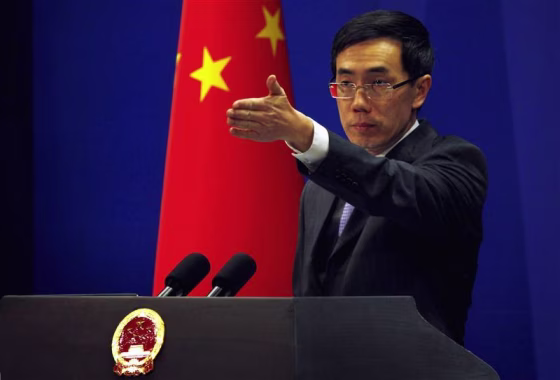 China's Foreign Ministry spokesman Liu Weimin gestures to a journalist during a news conference in Beijing