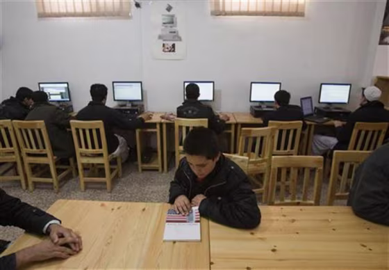 Afghan boy looks at educational book as others use Internet at Lincoln U.S. support library in Herat
