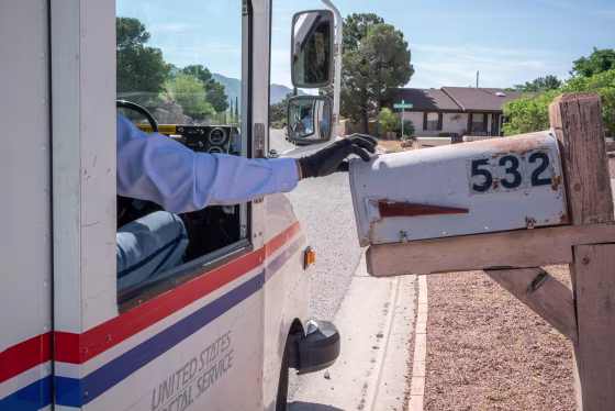 Image: United States Postal Service mail carrier Frank Colon, 59, delivers mail amid the coronavirus pandemic.