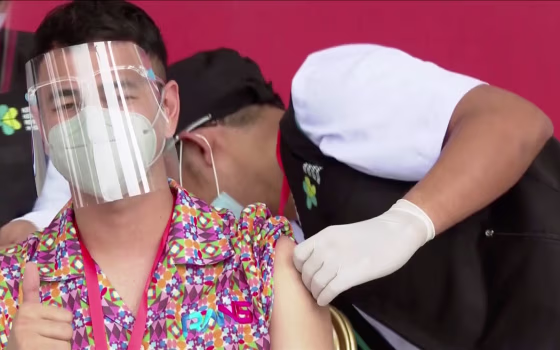 Indonesian influencer Raffi Ahmad gestures while receiving a shot of the Covid-19 vaccine