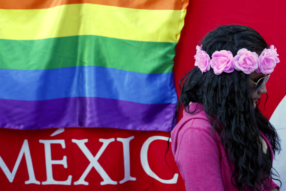 A woman walks past a rainbow flag hung on the outside of a tent offering free HIV testing, part of events to mark International Day Against Homophobia, Transphobia and Biphobia, in the Alameda park in central Mexico City on May 17, 2018.