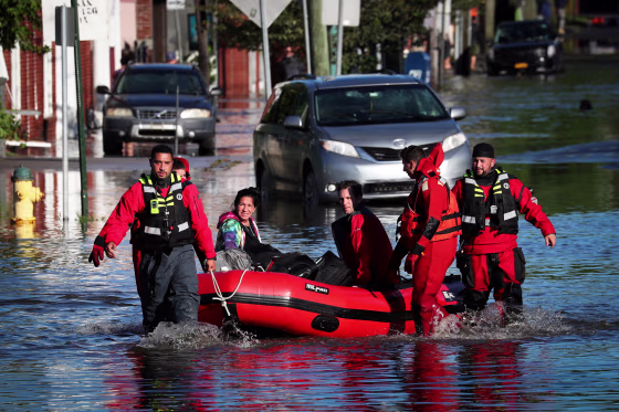 First responders pull local residents in a boat as they perform rescues of people trapped by floodwaters after the remnants of Tropical Storm Ida brought drenching rain, flash floods and tornadoes to parts of the northeast in Mamaroneck, N.Y., on Sept. 2, 2021.