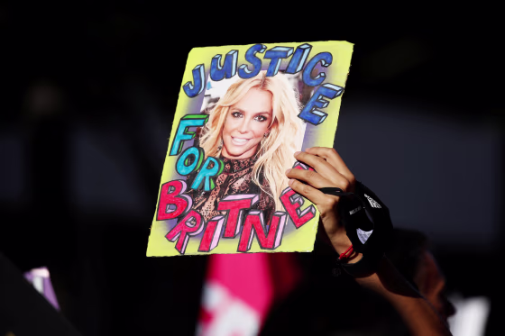 A supporter of Britney Spears holds up a picture of the pop star with the words "Justice for Britney" during celebrations for the termination of her conservatorship outside the Stanley Mosk Courthouse in Los Angeles on Nov. 12, 2021.