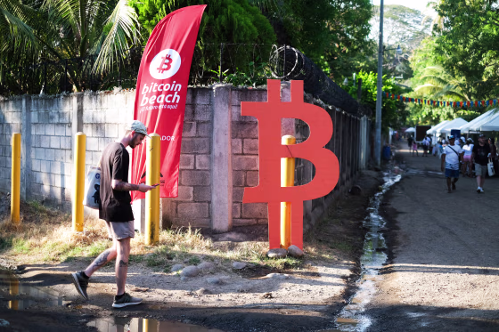 A man walks by a Bitcoin sign in Chiltiupan, El Salvador, on Nov. 18, 2021.