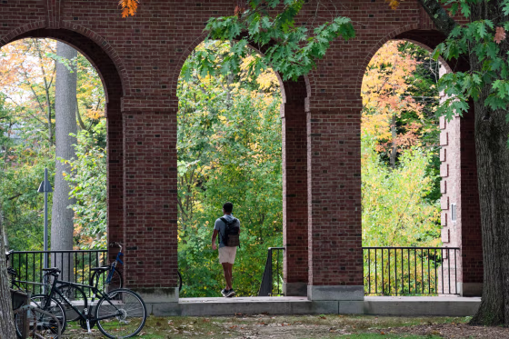 A student walks between dormitory buildings on the campus of Dartmouth College in Hanover, N.H., on Oct. 15, 2021.