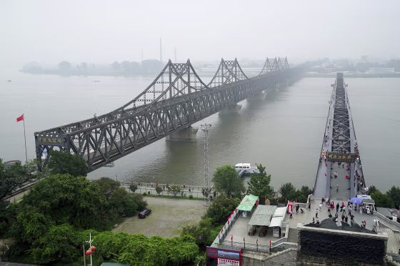 Visitors walk across the Yalu River Broken Bridge, right, next to the Friendship Bridge connecting China and North Korea in September 2017.