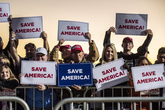 Attendees hold up signs at a rally for former President Trump at the Montgomery County Fairgrounds on Saturday, Jan. 29, 2022 in Conroe, Texas