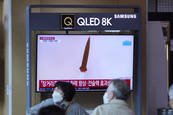 A TV screen shows a news program reporting about a test-firing of a newly developed tactical guided weapon, at a train station in Seoul, South Korea on Sunday.