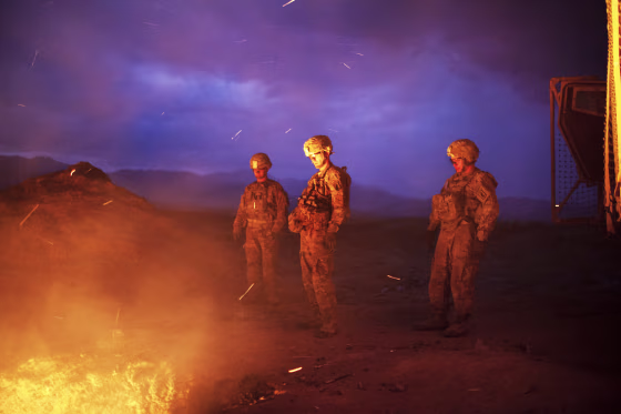 Soldiers burn trash in a burn pit