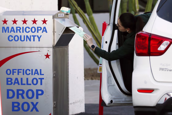 A voter drops off a ballot for the Arizona Democratic presidential primary in Phoenix on March 17, 2020.