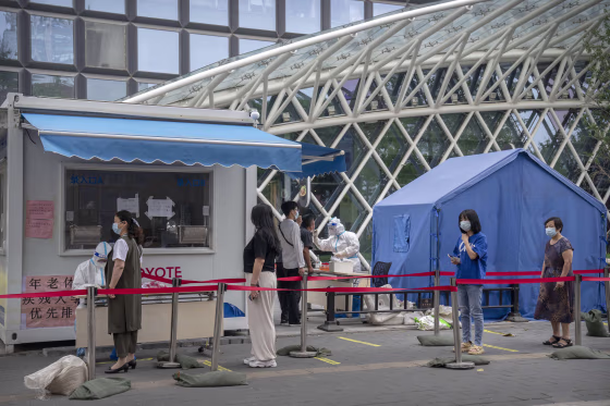 People stand in line for Covid tests in Beijing on Thursday.
