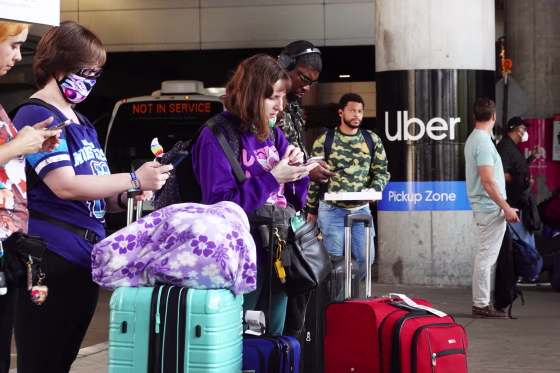Travelers wait for an Uber