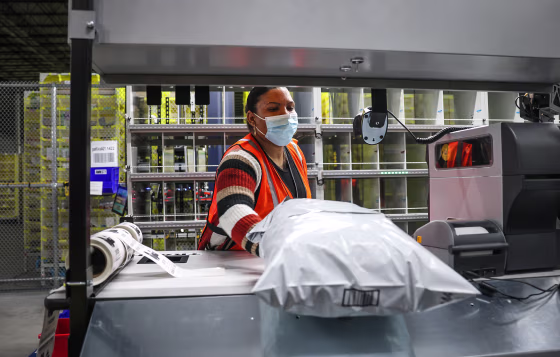 An Amazon employee packs items to be shipped out to customers inside Amazons Bridgewater "mini-fulfillment center" in Bridgewater, Mass., on March 16, 2022.