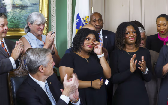 Image: Deanna Cook wipes away tears after Governor Charlie Baker signed the CROWN Act at the Massachusetts State House on July 26, 2022 in Boston.