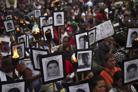 Image: The parents of 43 missing students from Ayotzinapa teachers school hold their portraits and torches during a march in Mexico City on April 26, 2016.