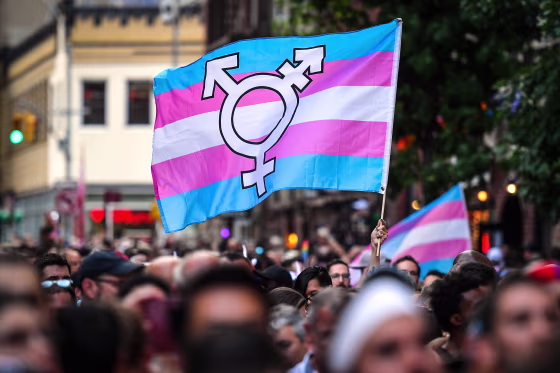 A person holds a transgender pride flag as people gather on Christopher Street outside the Stonewall Inn for a rally to mark the 50th anniversary of the Stonewall Riots in New York on June 28, 2019.