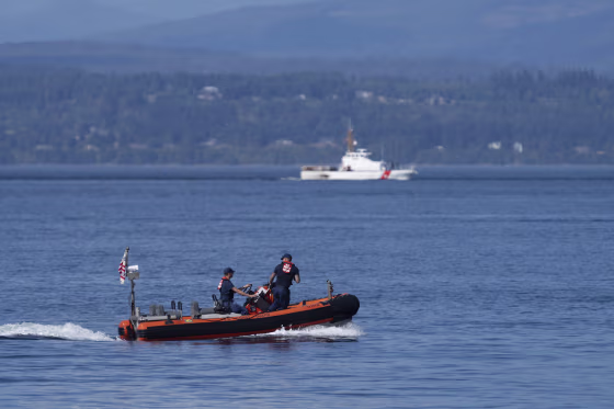 A pair of Coast Guard vessels search the area near Seattle where a chartered floatplane carrying 10 people crashed Sunday evening. The search was called off Monday afternoon.