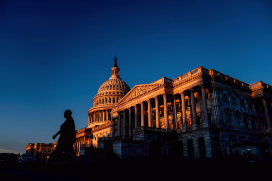 Image: A pedestrian walks past the US Capitol