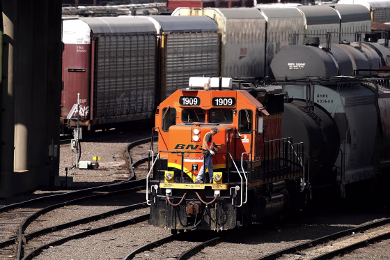 A worker boards a locomotive at a BNSF rail yard on in Kansas City, Kan.