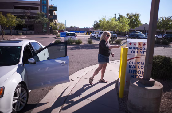 A woman drops her ballot for the upcoming midterm elections in the drop box near the Maricopa County Juvenile Court Center in Mesa, Arizona on October 25, 2022.