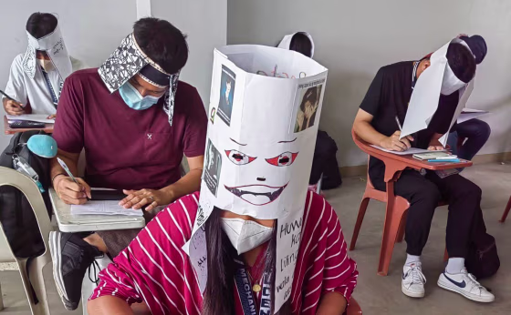 Students at Bicol University College of Engineering in Legazpi City, the Philippines, take an exam on Oct. 17, 2022, while wearing 'anti-cheating hats' they designed as part of an assignment