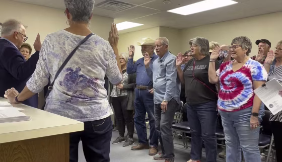 Nye County Clerk Mark Kampf, left, swears in a group of residents Wednesday who will hand count early ballots in Pahrump, Nev.