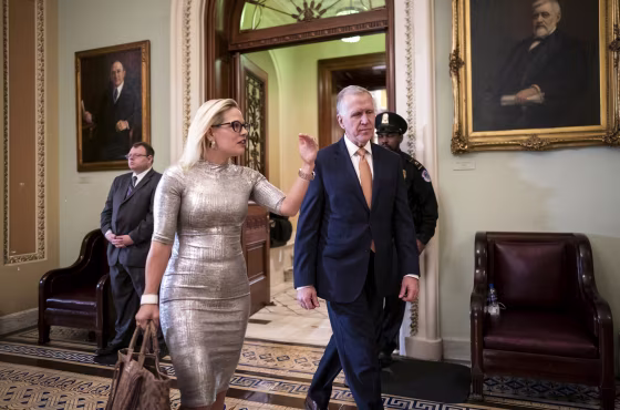 Sens. Kyrsten Sinema, D-Ariz., left, and Thom Tillis, R-N.C., leave the Senate chamber on Feb. 25, 2020.