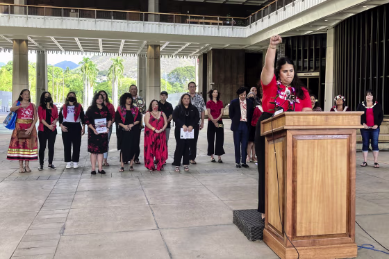 Makanalani Gomes, of AF3IRM, a feminist and decolonization organization, holds a fist in the air as she discusses a report on missing and murdered Native Hawaiian women on Dec. 14, 2022 in Honolulu.