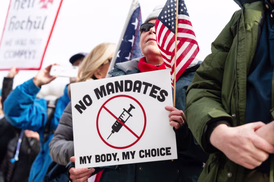 A demonstrator holds a sign during an anti-vaccine mandate rally