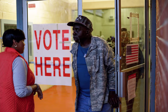 Voters exit a polling station at the National Guard Military Base during the presidential primary in Camden, Ala.,