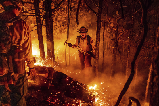 Firefighter Christian Mendoza manages a backfire, flames lit by firefighters to burn off vegetation, while battling the Mosquito Fire in Placer County, Calif., on Sept. 13, 2022.