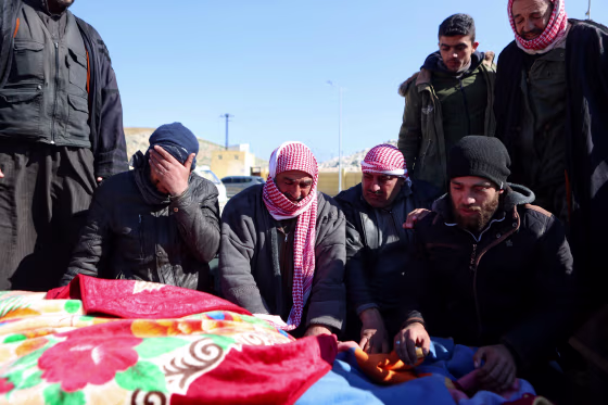 Image: Syrian men mourn as they identify a body of a relative killed in the earthquake after its arrival at the Bab al-Hawa border crossing near Syria and Turkey on Feb. 8, 2023.